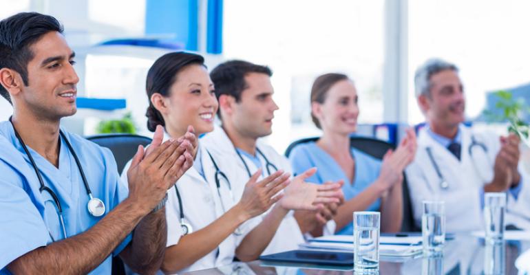 Physicians applauding at a meeting