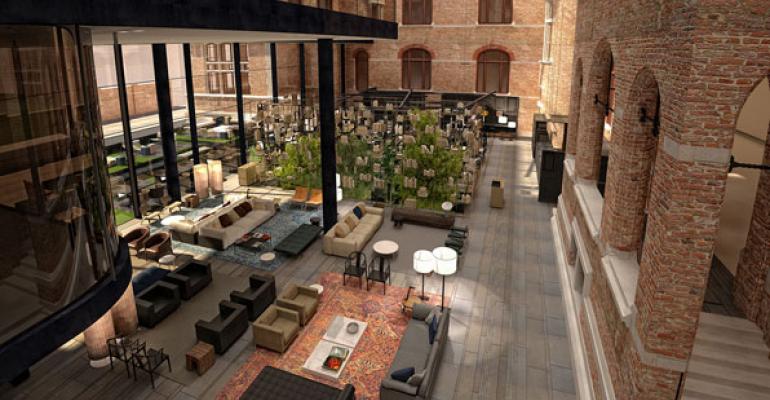 The lobby at Conservatorium Hotel Amsterdam features exposed brick and wood beams of the former music conservatory