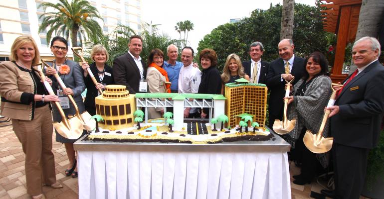 The Gary Sain Memorial Skybridge cake cutting ceremony Pictured left to right Victoria Hall Rosen Plaza Yulita Osuba OCCC Jan Addison OCCC Scott Boyd Orange County Commissioner Teresa Jacobs Orange County Mayor Harris Rosen Rosen Hotels amp Resorts David Ramirez executive pastry chef Rosen Hotels amp Resorts Pamela Sain Maria Triscari International Drive Chamber of Commerce Pete Clarke Orange County Commissioner George Aguel Visit Orlando Leslie Menichini Rosen Hotels amp Resorts Gary Hudson Rosen Plaza