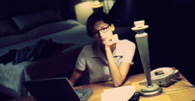 Businesswoman working on laptop at hotel room desk