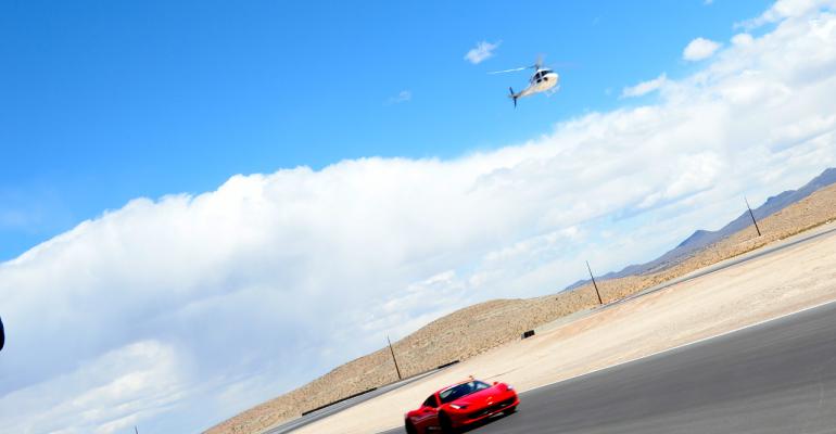 Cars racing on SPEEDVEGAS track with helicopter overhead