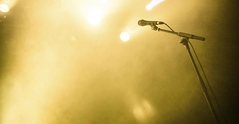 microphone stand on empty stage with yellow spotlights