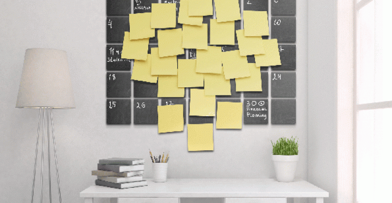 Office with wall calendar covered in PostIt notes