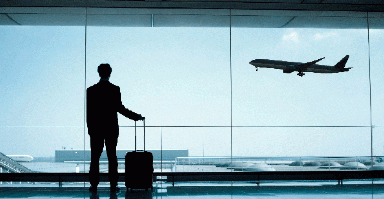 Business traveler at airport watching plane take off