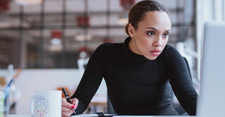 woman taking notes from a computer