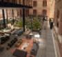 The lobby at Conservatorium Hotel Amsterdam features exposed brick and wood beams of the former music conservatory