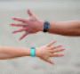 Male and female arms wearing Fitbits