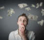 Woman looking up at dollars falling through the air