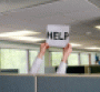 Hands in cubicle holding up Help sign