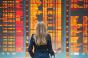 Woman traveler in front of international airport departure board