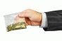 Businessman arm holding baggie of marijuana