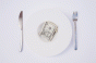 Dollars on a plate with knife and fork
