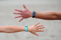 Male and female arms wearing Fitbits