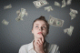 Woman looking up at dollars falling through the air