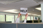 Hands in cubicle holding up Help sign
