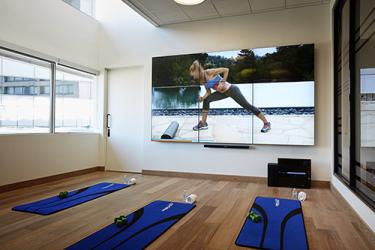 Exercise videos run on the fitness studio's video wall.